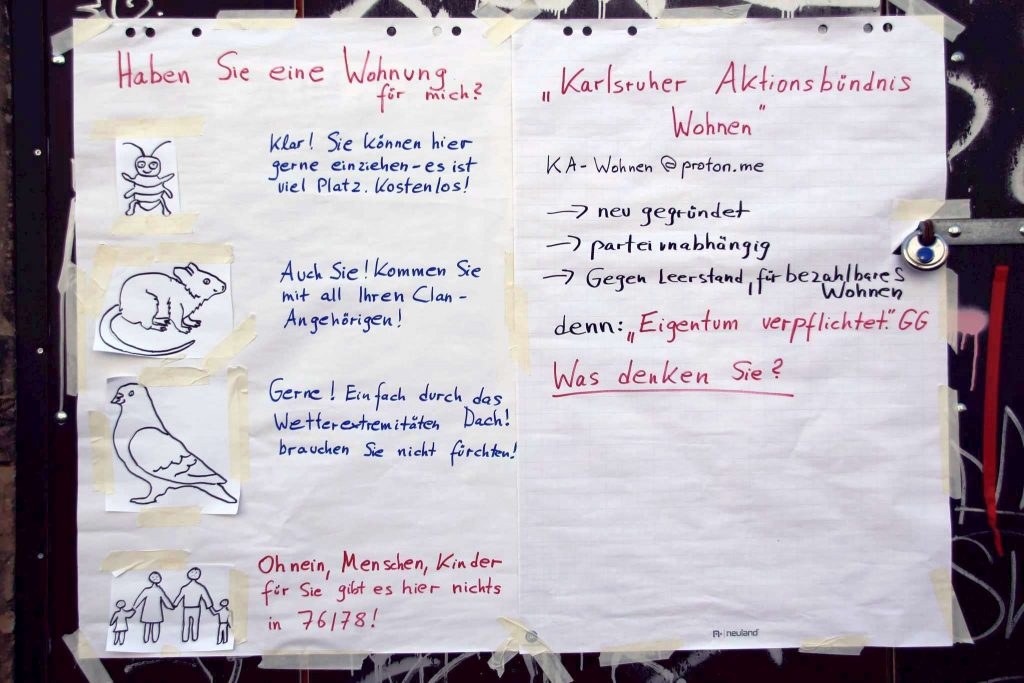 Ein Plakat hat auf der linken Seite die Überschrift: "Haben Sie eine Wohnung für mich? Neben einer gezeichneten Ungeziefer steht der Text: "Klar, Sie können hier gern einziehen. Es ist viel Platz! Kostenlos!" Neben einer gezeichneten Ratte steht der Text: "Auch Sie! Kommen sie mit all Ihren Clan-Angehörigen!" Neben einer gezeichneten Taube steht der Text: "Gerne! Einfach durch das Dach! Wetterextreme brauchen Sie nicht zu fürchten!" Auf der rechten Seite steht: Karlsruher Aktionsbündnis Wohnen KA-Wohnen@proton.me - neu gegründet - parteiunabhängig - gegen Leerstand, für bezahlbares Wohnen denn: Eigentum verpflichtet. GG Was denken Sie?